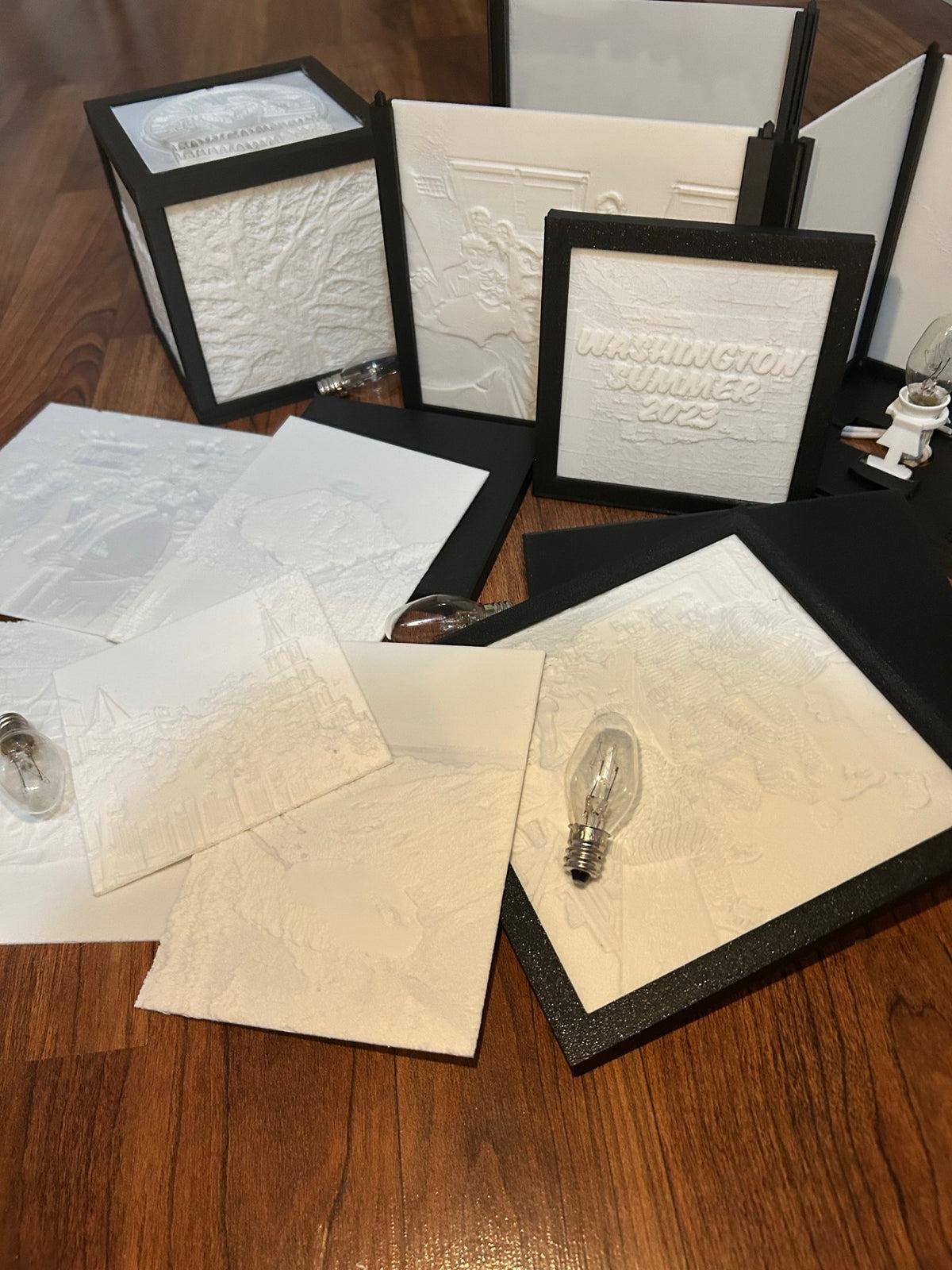Assortment of lithophane photo panels, frames and bulbs on a table
